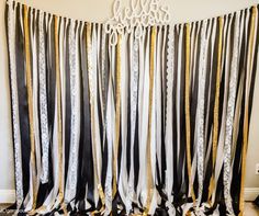 a black and white curtain with gold foil on the bottom is hanging in front of a wall