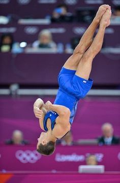 a man doing a handstand on the balance beam