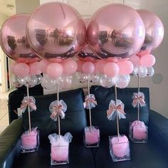 some pink candles and balloons on a couch