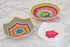 three crocheted bowls on a marble surface