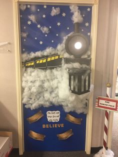 a door decorated to look like a train with clouds and stars on it, next to a teddy bear