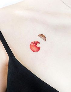 a woman with a red apple tattoo on her chest