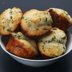 a white bowl filled with mini muffins covered in cheese and parmesan