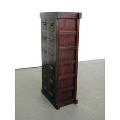 a tall wooden cabinet sitting on top of a cement floor next to a white wall