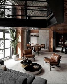 a living room filled with lots of furniture next to a tall window covered in plants