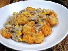 a white plate topped with tater tots and corn