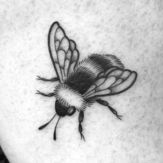 a black and white photo of a bee on the back of a woman's stomach