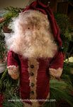 a santa clause doll standing next to a christmas tree