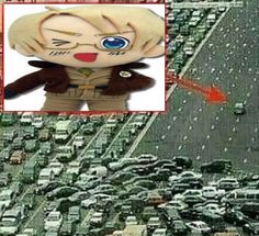 an aerial view of a city with lots of cars in the street and a doll that looks like it is flying through the air