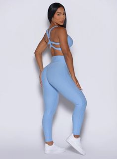 a woman in light blue sports bra top and leggings posing for the camera