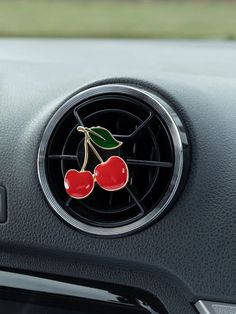 two cherries are attached to the center console of a car's steering wheel