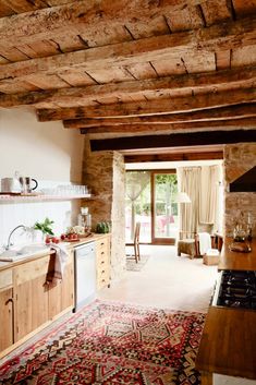 a kitchen area with a rug, sink and stove top oven in the middle of it