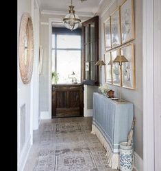 the hallway is decorated in white and blue with pictures on the wall, along with an antique radiator