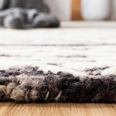 an area rug on the floor in front of a cat laying on it's side