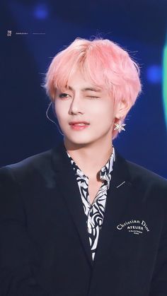 a man with pink hair wearing a black jacket