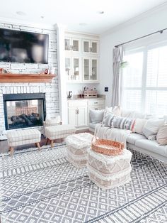 a living room filled with furniture and a flat screen tv mounted on the wall above a fire place