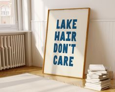 a poster with the words lake hair don't care on it next to a pile of books