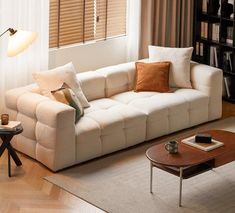 a living room with a couch, coffee table and bookshelf in the corner