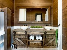 a bathroom with two sinks, mirrors and wooden cabinets on the wall next to each other