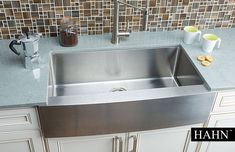 a stainless steel sink in a kitchen with tiled backsplash and countertop space