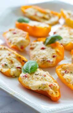 stuffed bell peppers with cheese and basil on a white platter, ready to be eaten