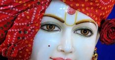 a close up of a woman's face wearing a red turban