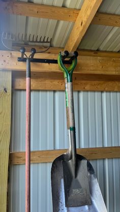 two shovels hanging from the ceiling in a garage