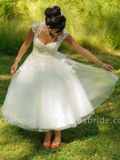 a woman in a white dress and red shoes is holding her hand out to the ground