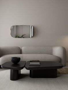 a living room with a couch, coffee table and mirror on the wall above it