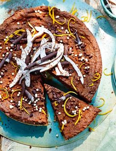 a chocolate cake with white and yellow sprinkles sits on a blue plate