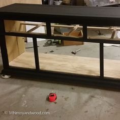 the inside of a cabinet with glass doors and tools on the floor next to it