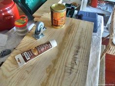 a wooden table with some paint on it and a can of glue next to it