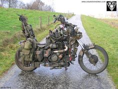 two motorcycles parked on the side of a road near a grassy field with trees in the background