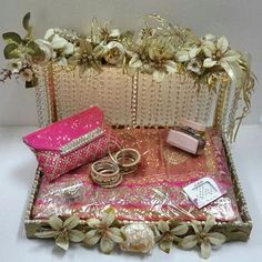 an assortment of wedding rings and jewelry in a gold case with flowers on the side