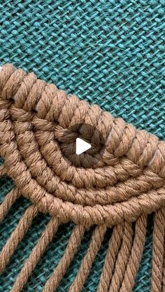 a piece of brown rope on top of a blue cloth with a white triangle in the middle