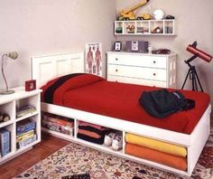 a bedroom with a bed, bookcases and other items on the floor in front of it