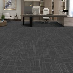 an office with gray carpeting and desks in the center, along with bookshelves