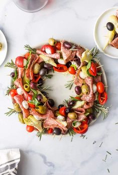 a platter filled with meat, olives, tomatoes and other food on plates