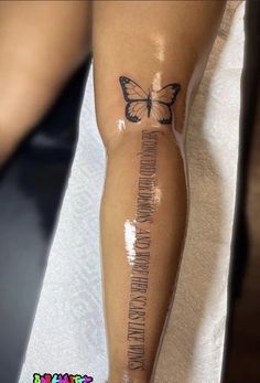 a woman's leg with a butterfly tattoo on it and words written across the legs