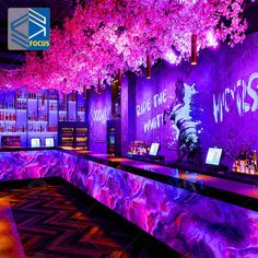 a bar with purple lighting and trees in the background