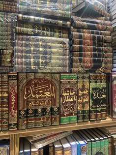 many books are stacked on top of each other in a book store, with arabic writing