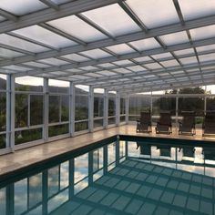 an indoor swimming pool surrounded by glass walls