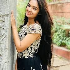 a woman standing next to a tree with long hair