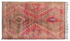 an old rug with pink and green colors