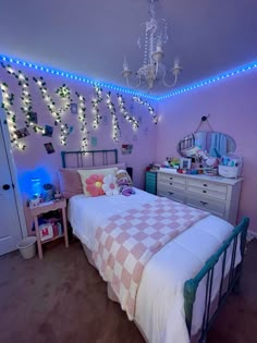 a bed room with a neatly made bed and a chandelier hanging from the ceiling