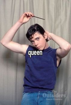 a young man holding his head with the words queen on it in front of him