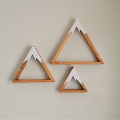 three wooden triangle shaped shelves mounted to the wall