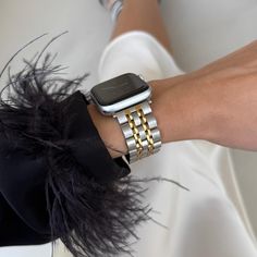 a woman's arm with two bracelets and an apple watch