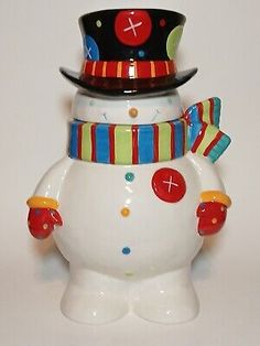 a ceramic snowman with a top hat and scarf on it's head,