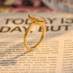 a close up of a gold ring on top of an open book with the words today is friday written in it